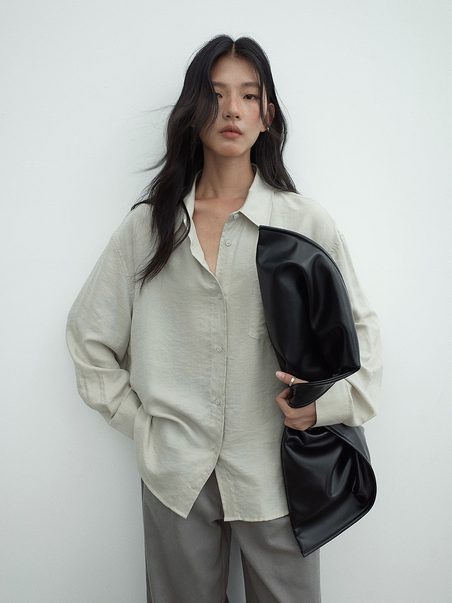 Woman holding a black clutch against a white background waering a women Long-sleeved Relaxed Fit Shirt