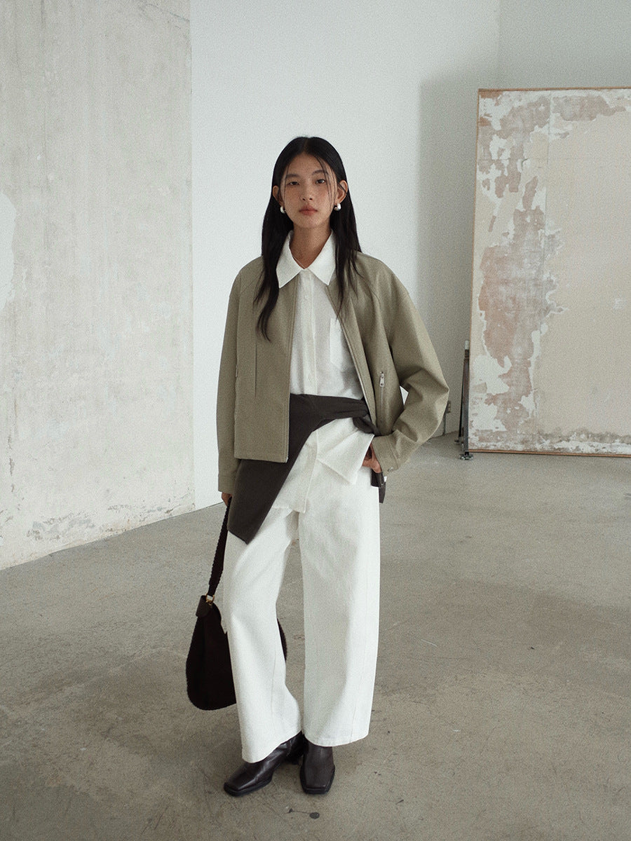 Woman wearing a beige jacket, white Long-sleeved Relaxed Fit Shirt, and white pants in an indoor setting.