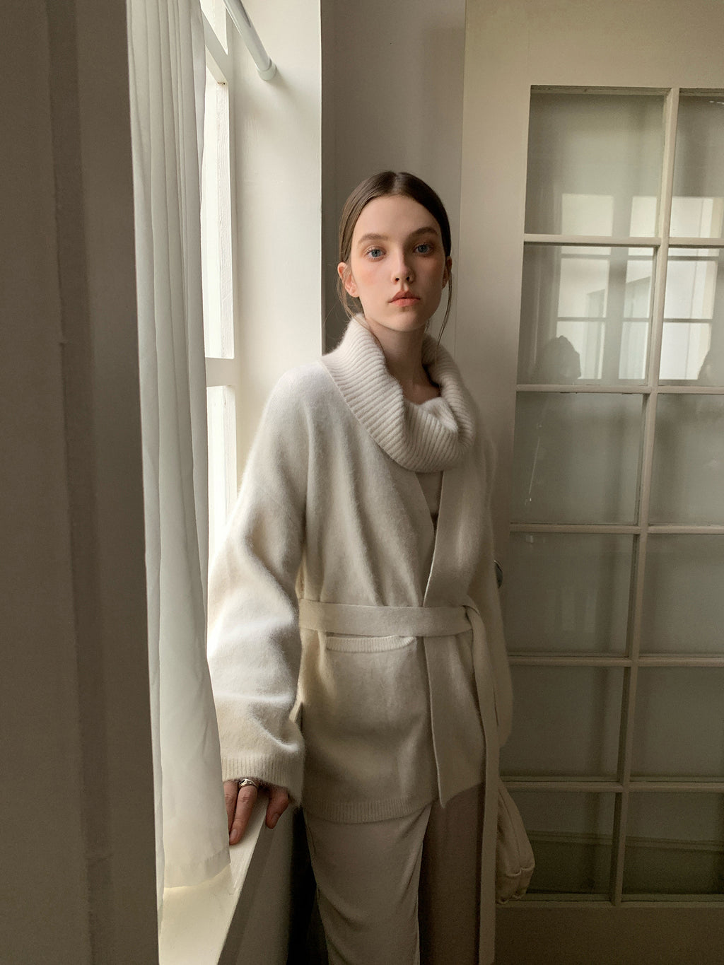 Woman wearing a Soft Fleece Mid-Thigh Long Cardigan Sweater Robe standing in a softly lit room.