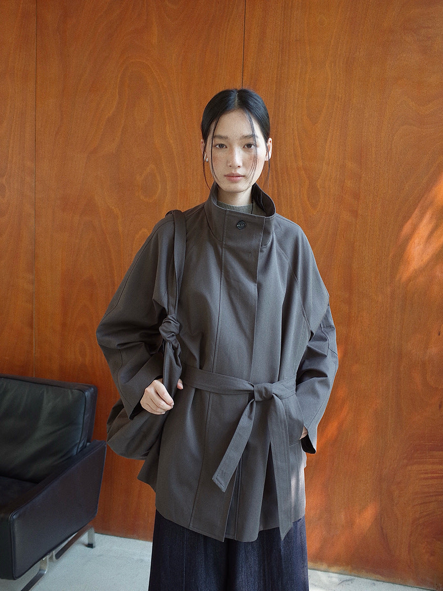 Person wearing a dark gray Stand-up Collar Mid-Length Trench Coat standing against a wooden wall.