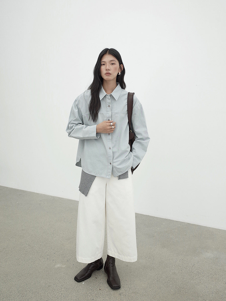 Person wearing a light gray shirt, white Cropped Wide-Leg Straight Jeans, and dark shoes against a plain background
