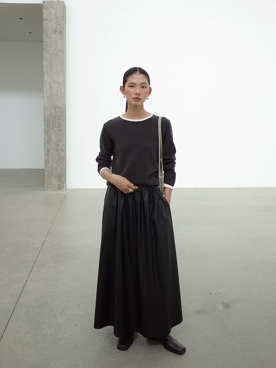 Woman wearing a Leather Drape Maxi A-Line Skirt outfit standing in a minimalistic indoor setting.