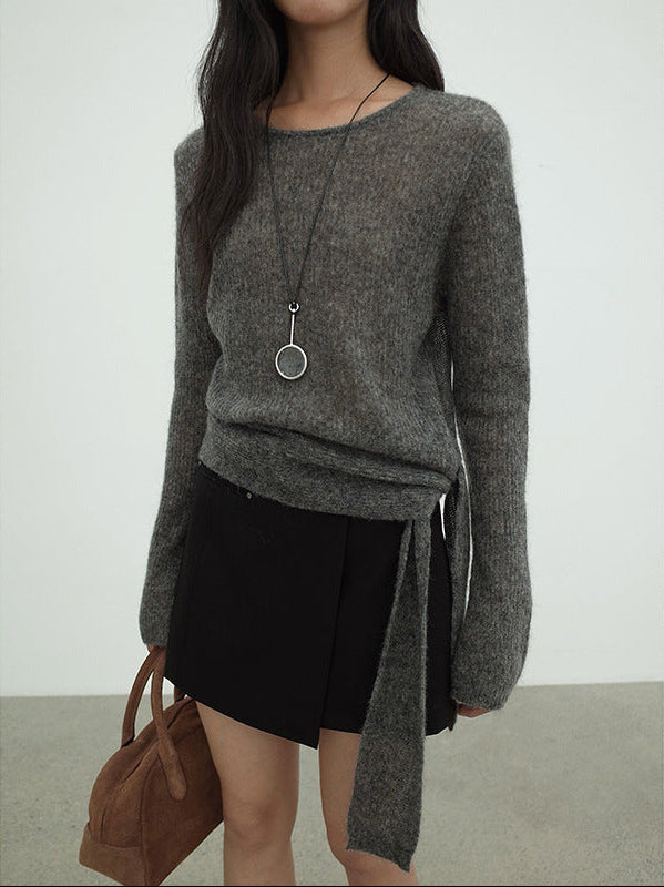 Person wearing a gray sweater with a black Irregular A-Line Short Mini Skirt and holding a brown bag against a white background