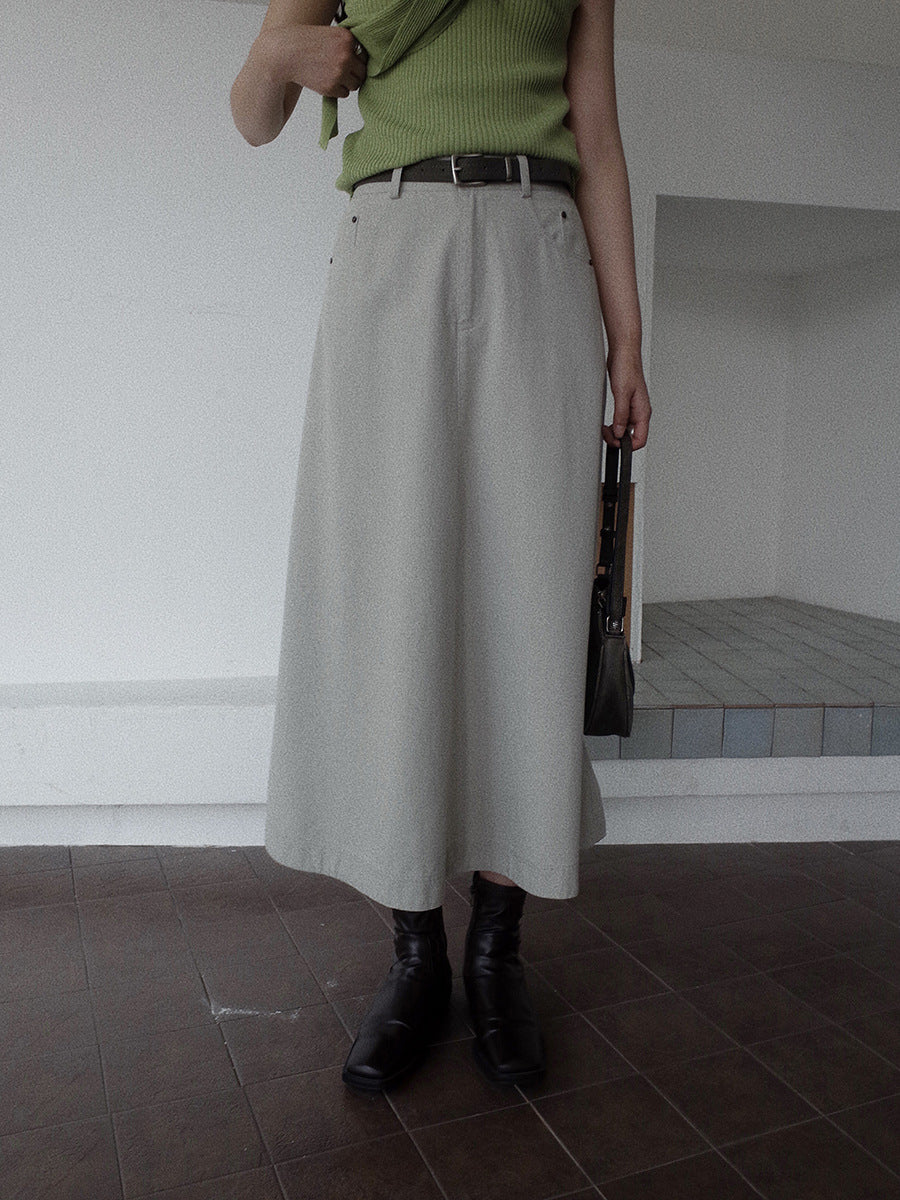 Person wearing a green top and beige Maxi Length A-Line Denim Skirt standing indoors.