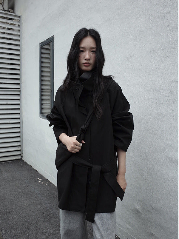Person wearing a black Stand-up Collar Mid-Length Trench Coat standing against a plain wall.