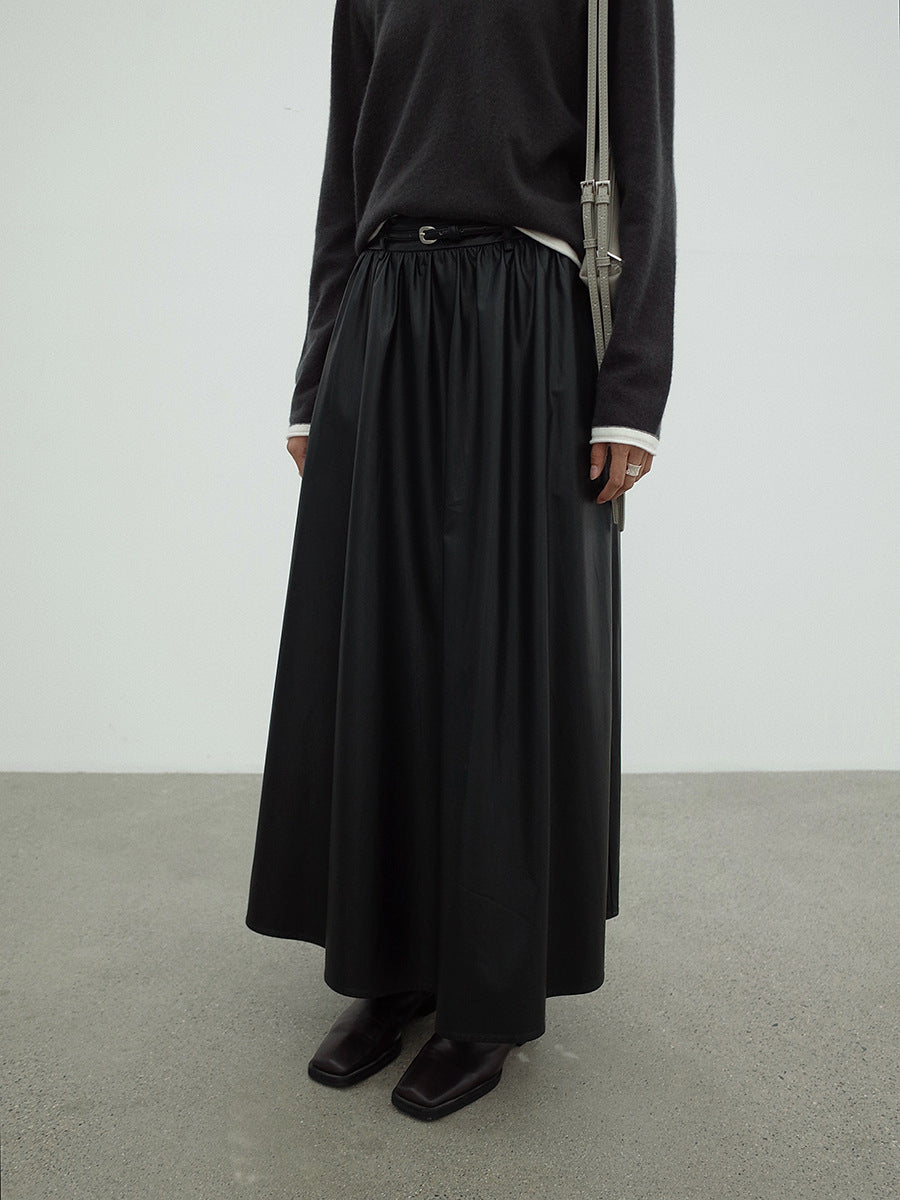 Woman wearing a long Leather Drape Maxi A-Line Skirt and black shoes against a white background
