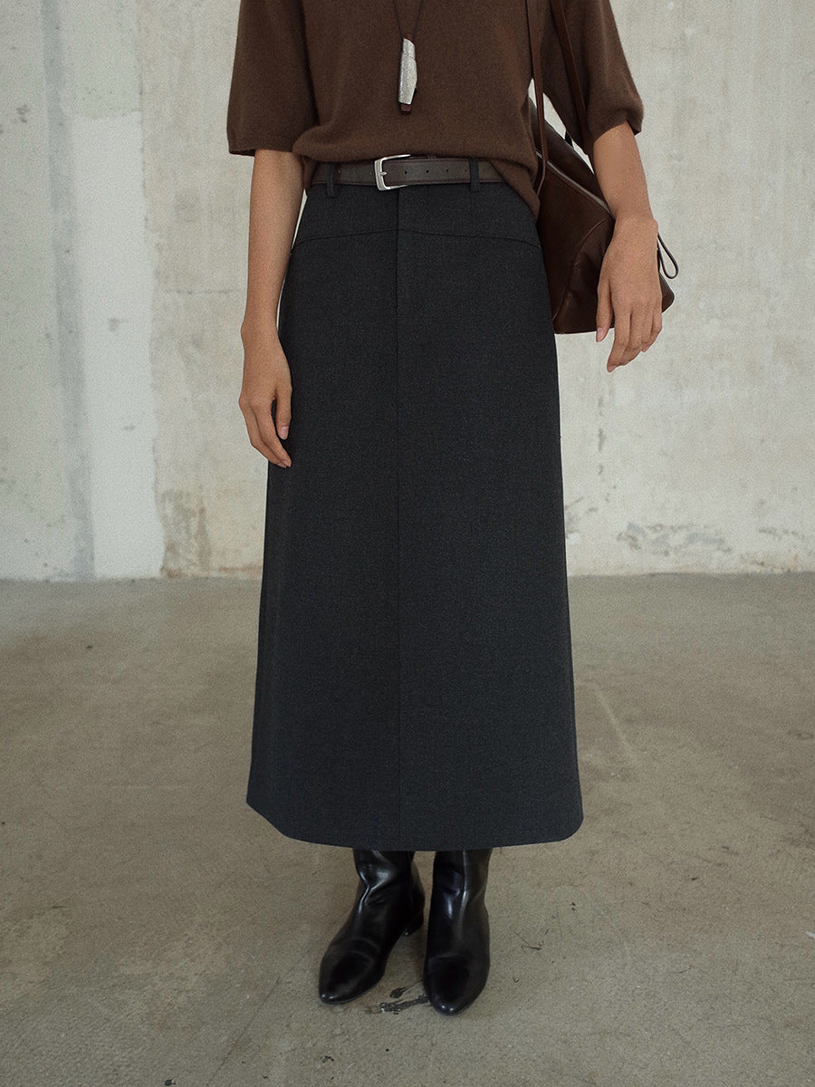 Person wearing a brown Smooth High-waisted A-line Maxi Skirt and black skirt against a plain background