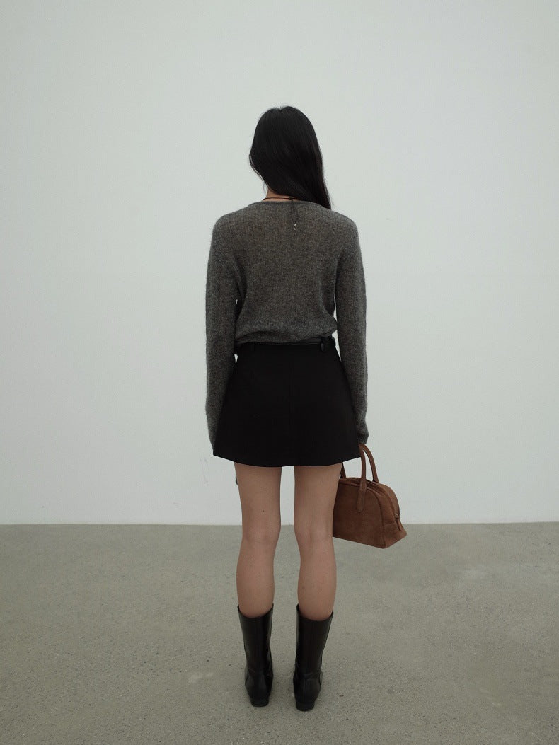 A woman is shown from behind wearing a gray Strap Waist Long-sleeved Mohair Wool Knitted Sweater, a black mini skirt, black knee-high boots, and holding a brown handbag against a minimalist white wall and gray floor.