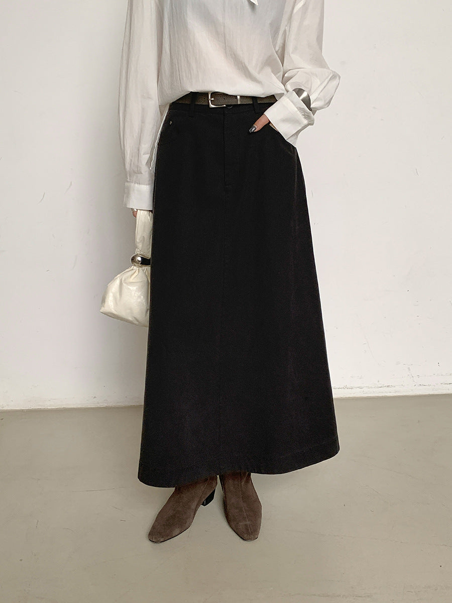 Person wearing a black Maxi Length A-Line Denim Skirt with a white shirt and brown shoes against a plain background