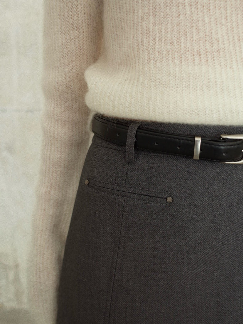 Close-up of a person wearing dark gray Irregular A-Line Short Mini Skirt with a black leather belt and a cream ribbed knit sweater.