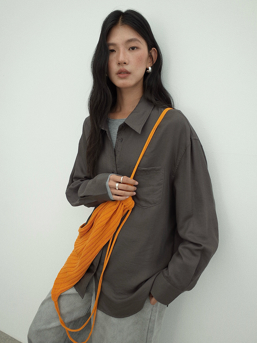 Woman holding an orange bag against a white background wearing a Long-sleeved Relaxed Fit Shirt