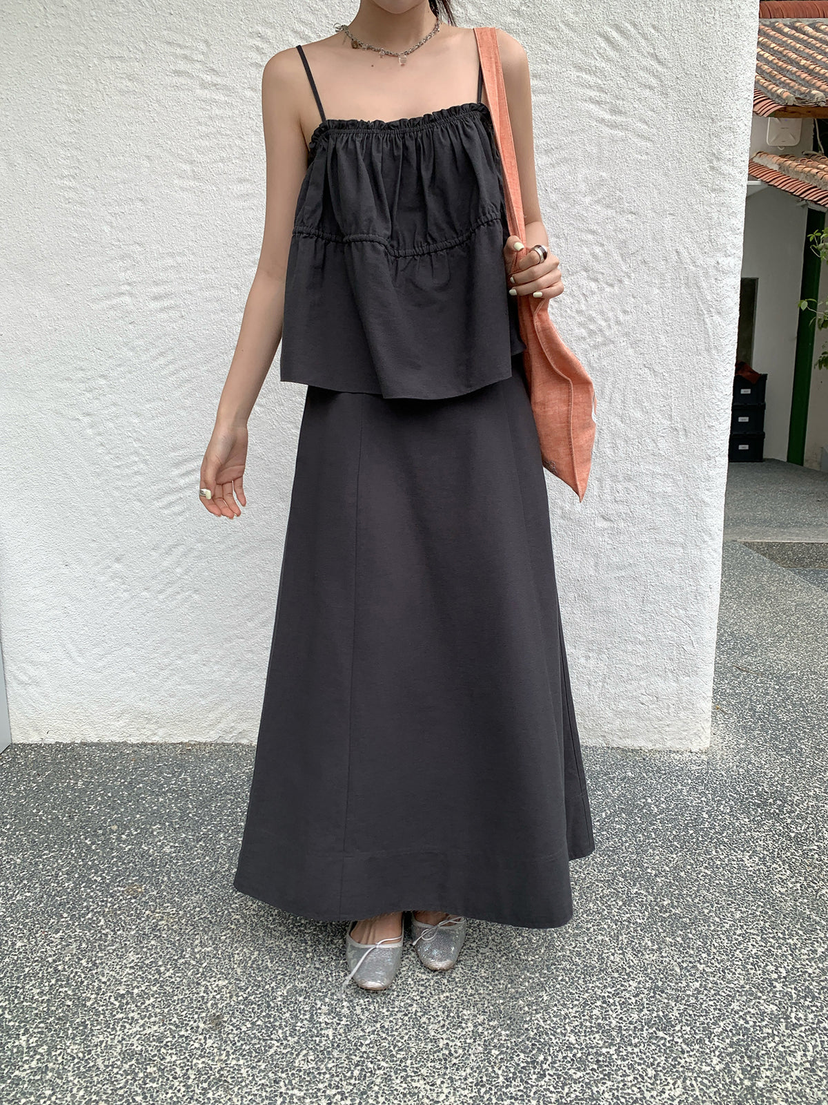 Person wearing a black Two-piece Raw Edge A-line Maxi Versatile Skirt outfit with a white wall background