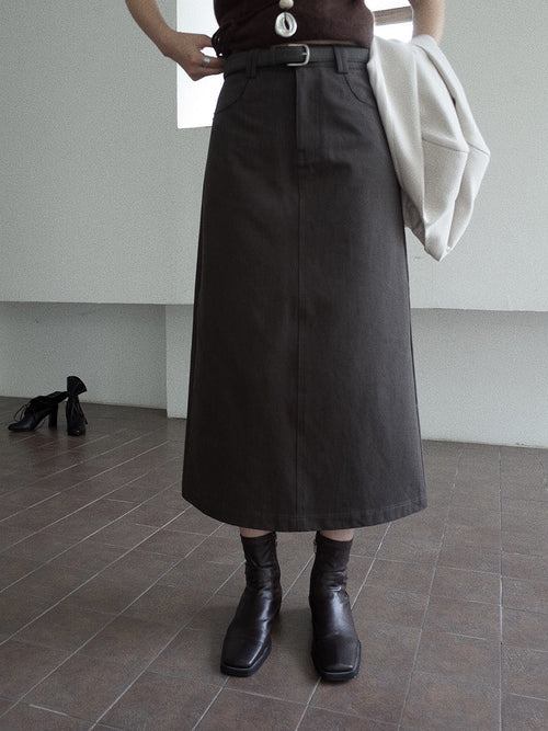 Person wearing a long dark grey A-line Midi Denim Skirt and black boots in an indoor setting.