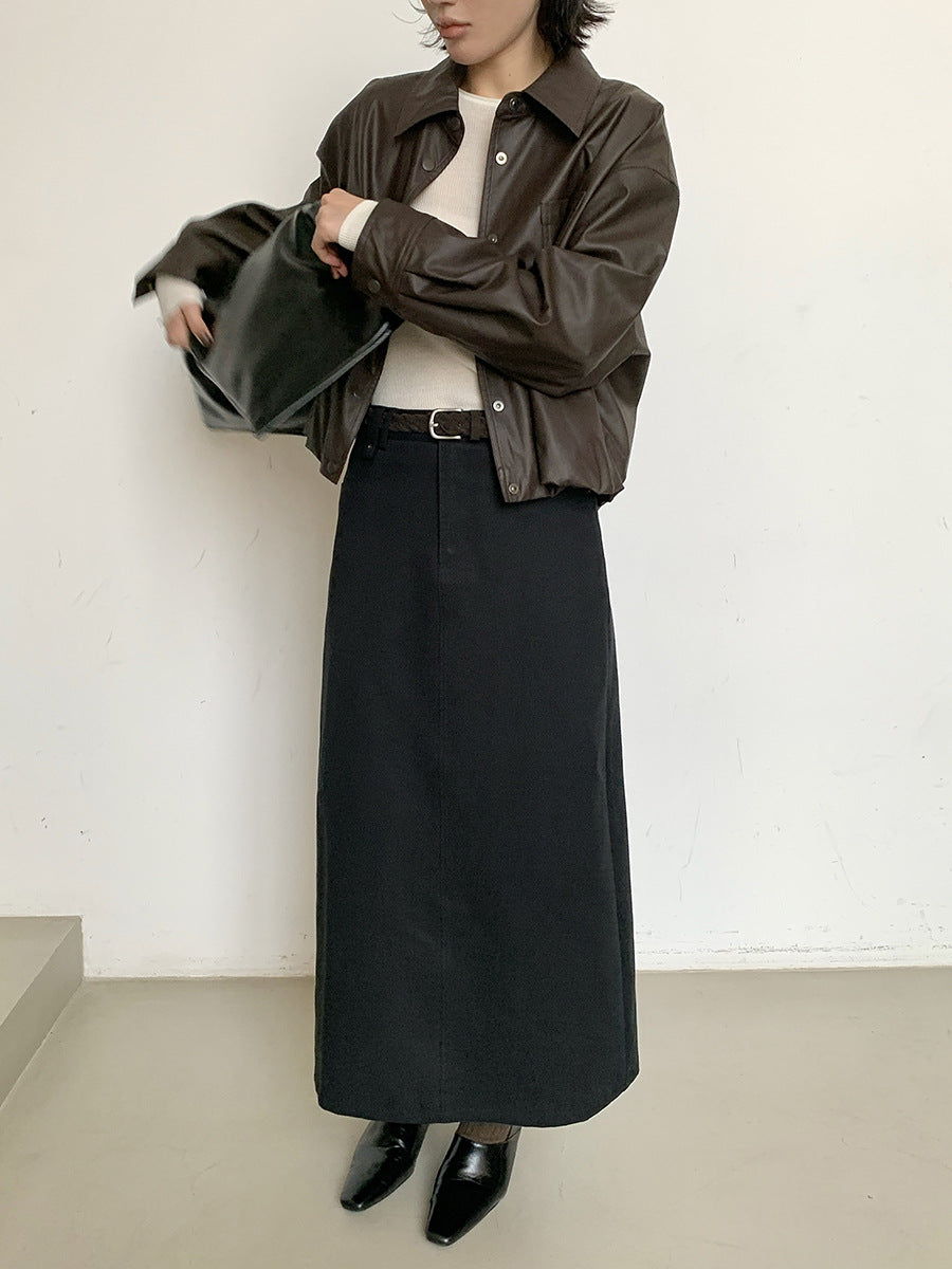 Woman wearing a brown leather jacket, white shirt, black long High-waisted A-line Maxi Skirt, and black shoes against a white background.