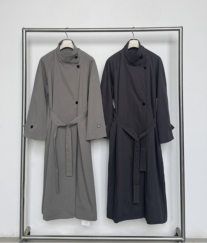 Two long coats, one gray and one black, hanging on a rack against a white background.