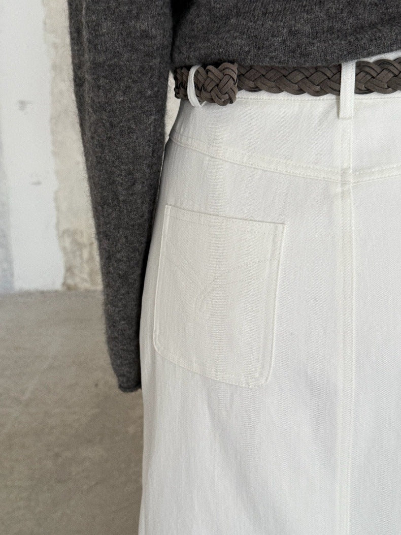 Close-up of a person wearing a white High-waisted A-line Maxi Skirt with back pockets, paired with a dark braided belt and a gray knit top.
